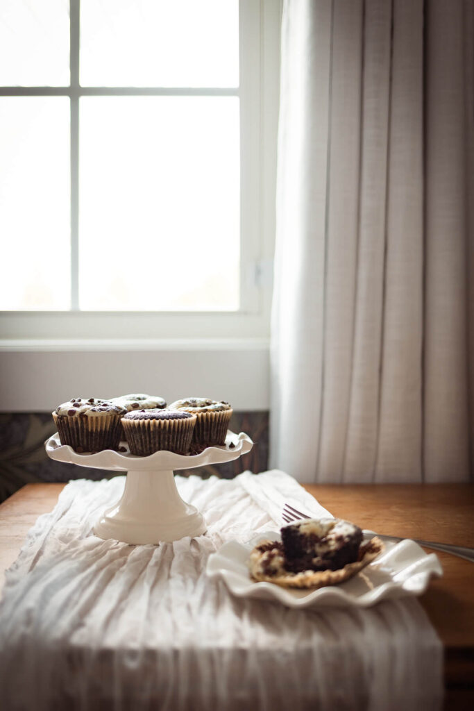 gluten free cream cheese cupcakes on a table in a front of window