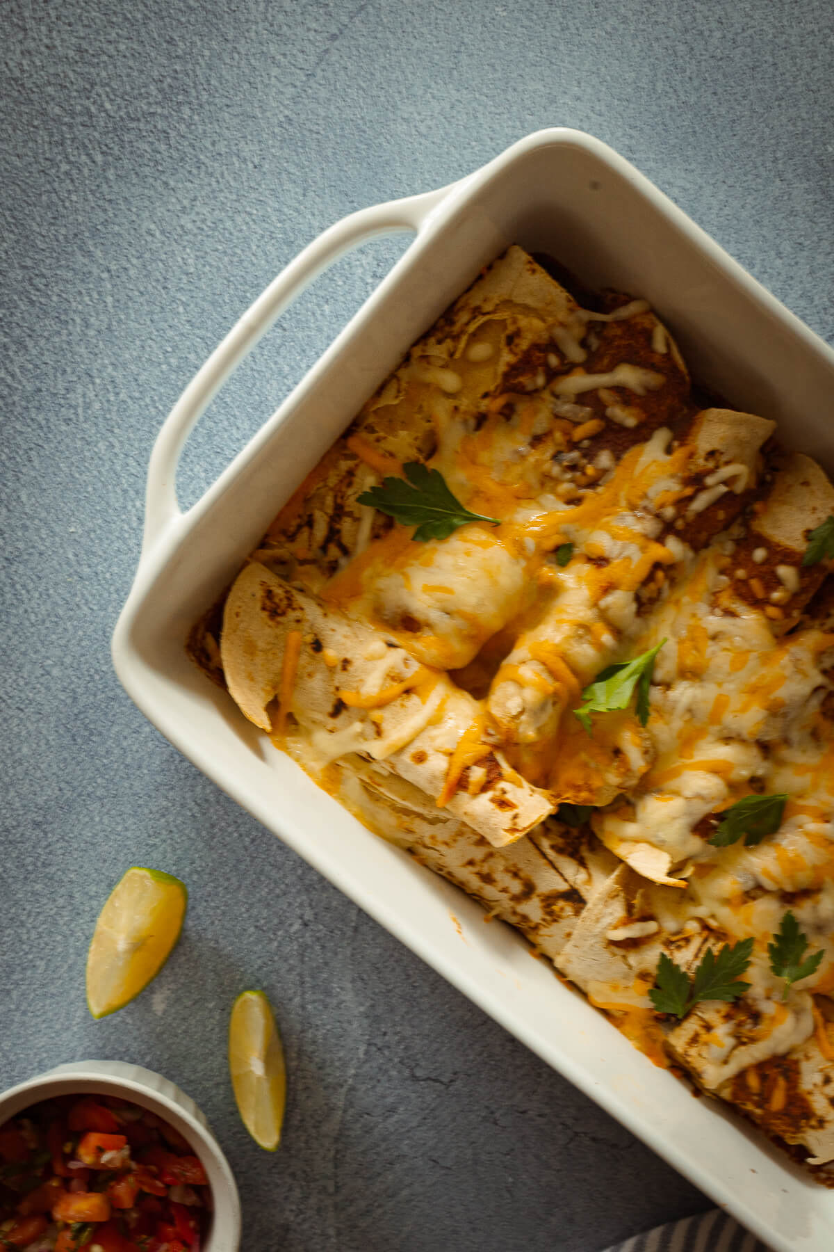 enchiladas in a 9x13 baking pan with melted cheese on top