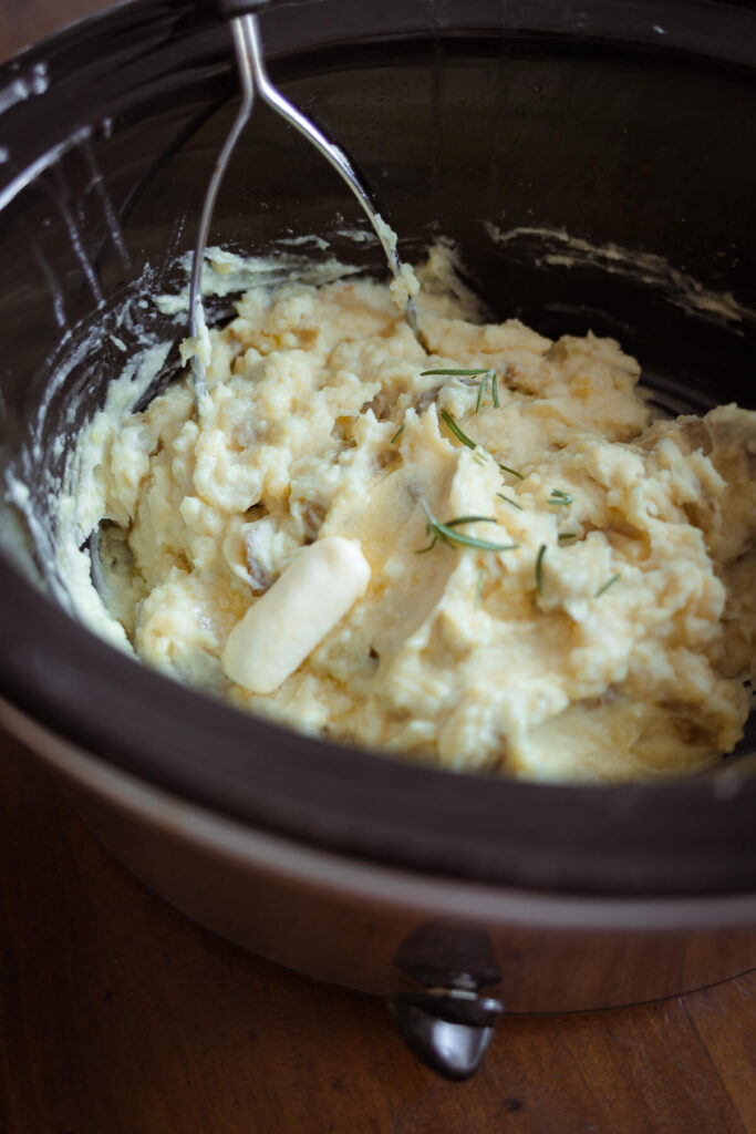 mashing potatoes in a slow cooker with butter