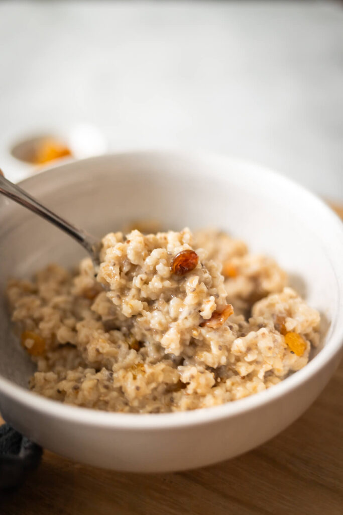 a spoonful of creamy brown sugar oatmeal with golden raisins and chia seeds