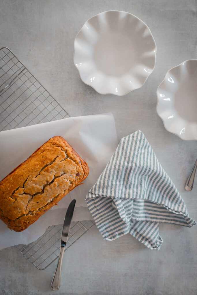 gluten free banana bread on a wire rack with two plates