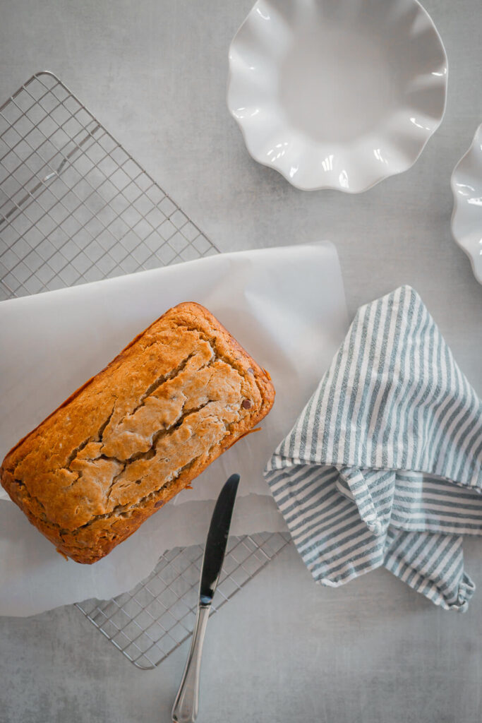 gluten free banana bread on a wire rack with two plates