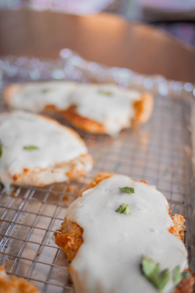 gluten free breaded chicken with cheese and parsley on top