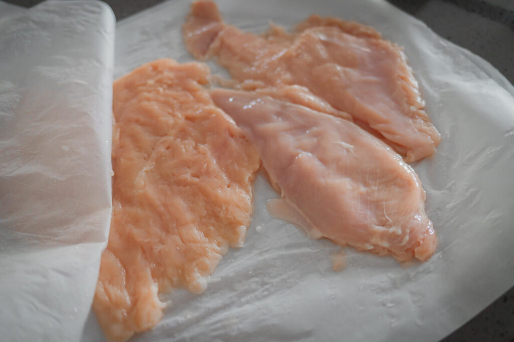 close up view of chicken breasts after they have been flattened.