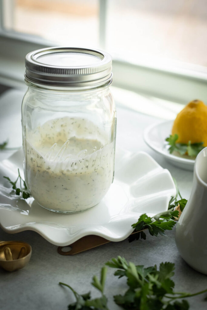 creamy homemade ranch dressing in a mason jar near a window