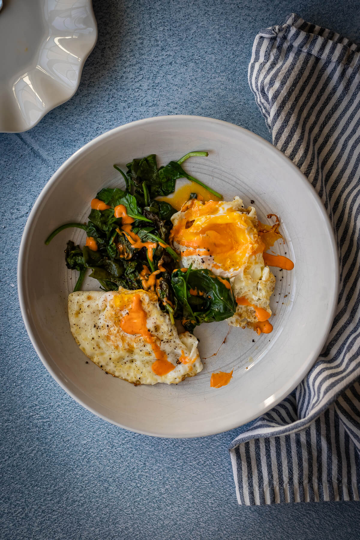 Fried Eggs with sauteed greens and sriracha mayo